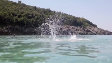 Profesyonel yüzücü denizde kelebek stili yüzüyor.