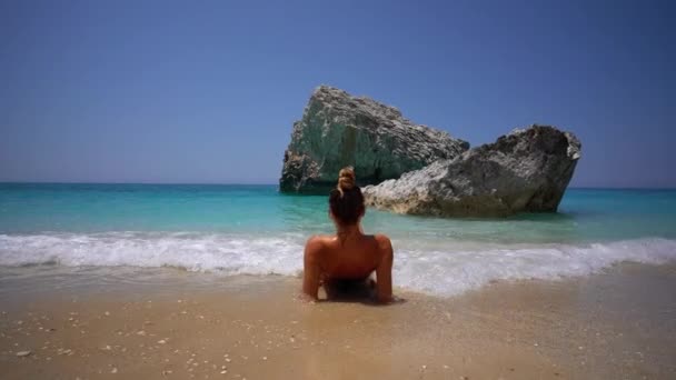 在莱夫卡达的Megali Petra海滩晒日光浴的年轻漂亮女人 — 图库视频影像