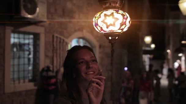 Дівчина Посміхається Граючи Блискучою Вуличною Люстрою — стокове відео