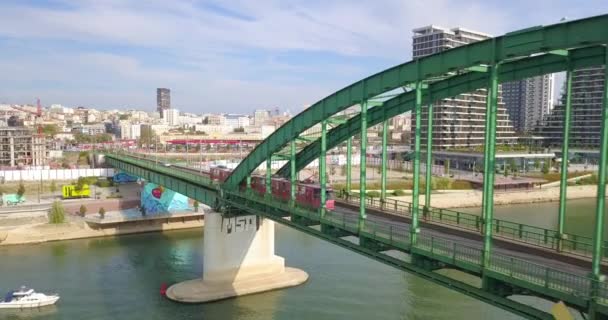 ベオグラードの旧鉄道橋を渡る赤いトラムウォーターフロント地区 — ストック動画