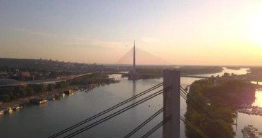 Gün batımında Belgrad 'daki Ada asma köprüsü ve eski demiryolu köprüsünün insansız hava aracı görüntüleri