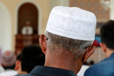 Al-Serkal Camii. Müslüman bir adam elinde kufi şapkasıyla dua ediyor. Phnom Penh. Kamboçya. 