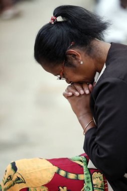 İyi Dostlar Akamasoa Cemaati ile Pazar Katolik ayini. Dua eden kadın. Antananarivo. Madagaskar.