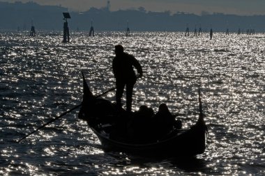 Büyük Kanal 'da, Gondol' da siyahlı gondolcu güneş ışığına karşı. Venedik. İtalya. 