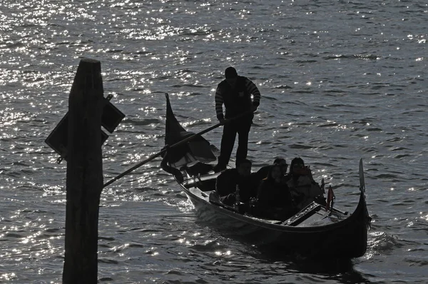 Büyük Kanal 'da, Gondol' da siyahlı gondolcu güneş ışığına karşı. Venedik. İtalya. 