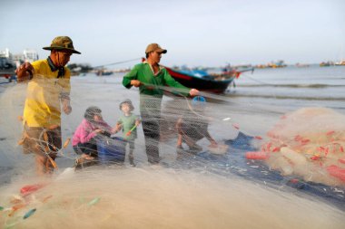 Tam Duong sahilinde balık ağlarını tamir eden balıkçılar. Vung Tau. Vietnam. 