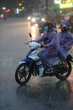 Şiddetli muson yağmurları. Saigon Caddesi 'nde motosiklet. Vietnam. 
