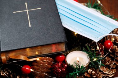 Advent çelengi, İncil ve cerrahi maske. Noel kompozisyonu. Fransa. 