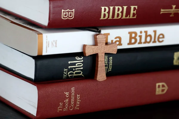 Fyra Olika Biblar Och Ett Kristet Kors Ett Bord — Stockfoto