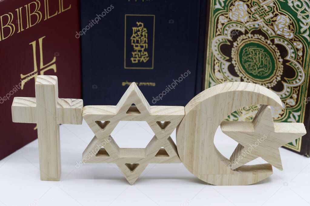 The three monotheistic religions. Christianity, Islam and judaism. Thorah, Quran and Bible with croos, star of David and muslim crescent.  Interreligious or interfaith symbols. France. 