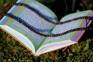 Apaçık bir Kuran ve tahta üzerinde Müslümanların dua boncukları.. 