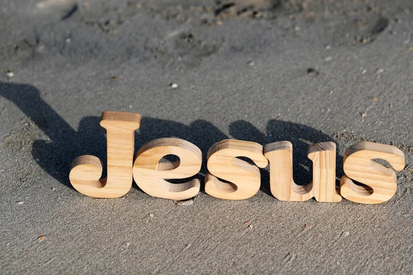 Sahildeki Kumların Üzerinde Kelimesini Oluşturan Tahta Harfler Hıristiyan Sembolü — Stok fotoğraf