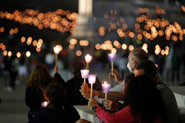Akşam ayininde Fatima 'ya yapılan hac sırasında ellerinde mumlarla ibadet edenler. Portekiz. 