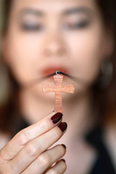 Christian woman wearing woodene cross pendant necklace.