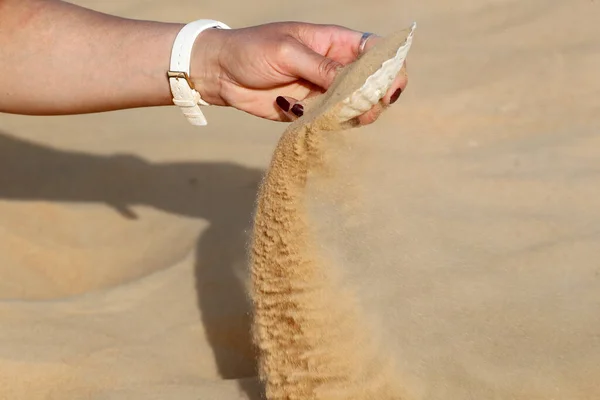 女性手在沙漠中从扇贝壳中释放沙子的剪影 祈祷和精神信仰的概念 — 图库照片