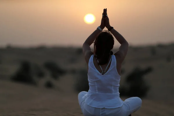 Sunset meditation in the desert at sunset.  Concept for religion, faith, prayer and spirituality. Dubai. United Arab Emirates.