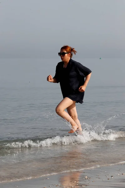 女人赤脚在海滩上奔跑 大不列颠及北爱尔兰联合王国 — 图库照片