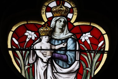 Saint Marien Kilisesi. Lekeli cam. Taç giymiş Bakire Meryem bebek İsa 'yı kollarında taşıyor. Mezilles. Fransa.