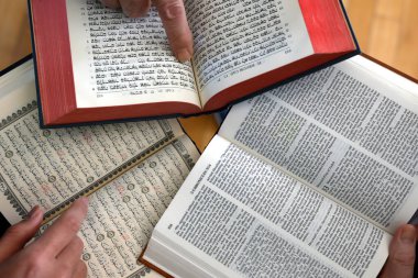 Üç tek tanrılı din. Bir Hıristiyan, bir Yahudi ve bir müslüman. Kitabı, Tevrat 'ı ve Kuran' ı okuyorlar. Barış ve dinler arası diyaloğun sembolü.