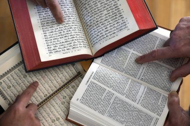 Üç tek tanrılı din. Bir Hıristiyan, bir Yahudi ve bir müslüman. Kitabı, Tevrat 'ı ve Kuran' ı okuyorlar. Barış ve dinler arası diyaloğun sembolü.