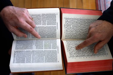 İki tek tanrılı din, Hristiyanlık ve Yahudilik. Tevrat 'ı ve İncil' i okuyan bir Yahudi ve Hıristiyan. Dinler arası diyaloğun sembolü..