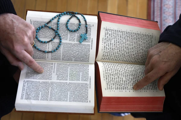 İki tek tanrılı din, Hristiyanlık ve Yahudilik. Tevrat 'ı ve İncil' i okuyan bir Yahudi ve Hıristiyan. Dinler arası diyaloğun sembolü..
