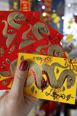 Çin ve Vietnam 'ın yeni yıl kutlamaları için kırmızı zarflı Asyalı kadın. Kırmızı renk iyi şansın sembolüdür. Yılan Yılı.