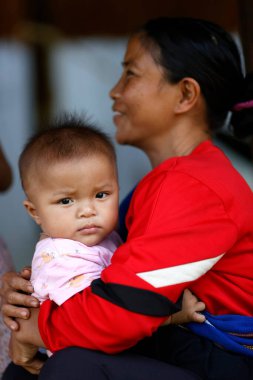 Kontum bölgesindeki Bahnar etnik köyü. Genç anne ve bebeği. Kontum. Vietnam.
