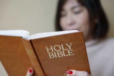 Evde İncil okuyan bir kadın..