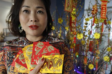 Çin ve Vietnam 'ın yeni yıl kutlamaları için kırmızı zarflı Asyalı kadın. Kırmızı renk iyi şansın sembolüdür. Yılan Yılı.