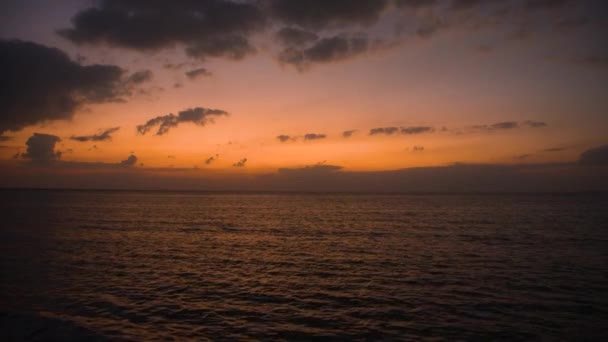 Una puesta de sol sobre un cuerpo de agua — Vídeo de stock