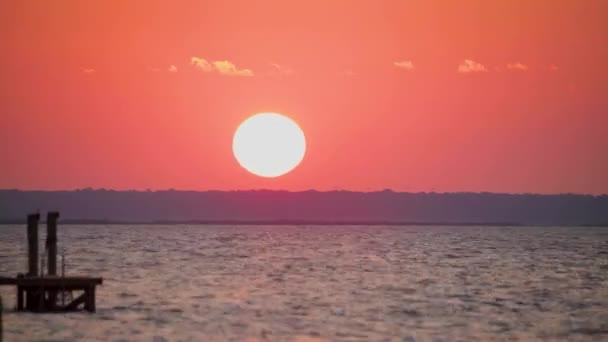 Una puesta de sol sobre un cuerpo de agua — Vídeo de stock