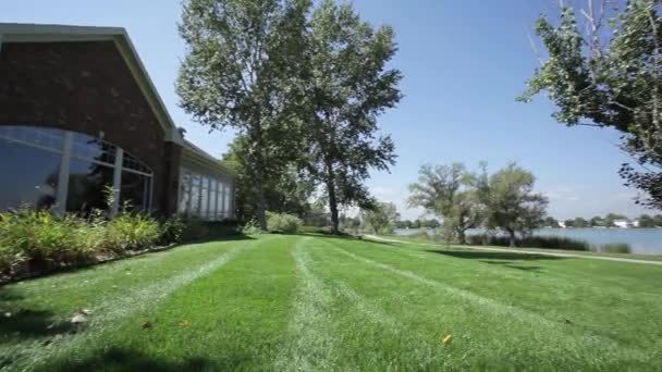 Eine große grüne Wiese vor einem Haus — Stockvideo