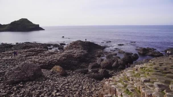 Une plage rocheuse à côté d'un plan d'eau — Video