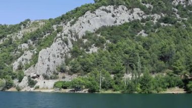 Ağaçlarla çevrili büyük bir su kütlesi.