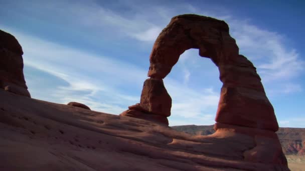 Un homme faisant un tour sur un rocher avec le parc national des Arches en arrière-plan — Video