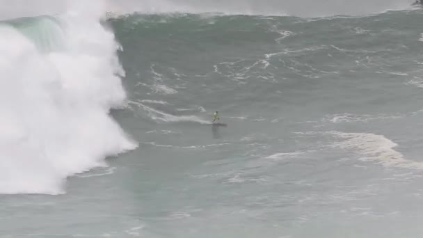 Osoba ujeżdżająca falę na desce surfingowej w wodzie — Wideo stockowe