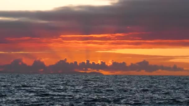 Una puesta de sol sobre un cuerpo de agua — Vídeo de stock