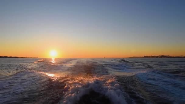 Una puesta de sol sobre un cuerpo de agua — Vídeo de stock