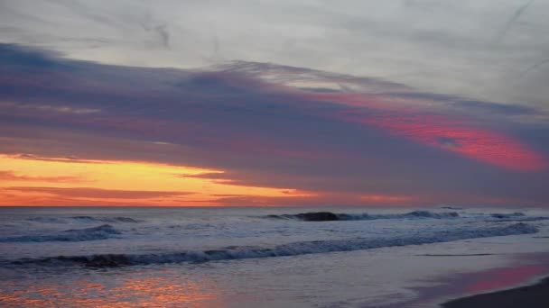 Una puesta de sol sobre un cuerpo de agua — Vídeo de stock