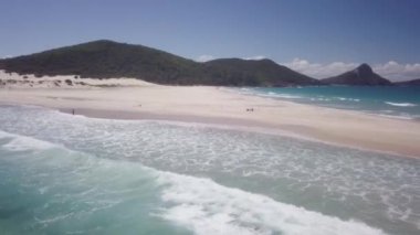 Arka planda dağ olan bir sahil.