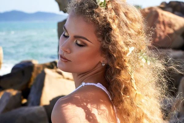 Retrato de niña bastante rizado con flores en la cabeza, vista al mar — Foto de Stock