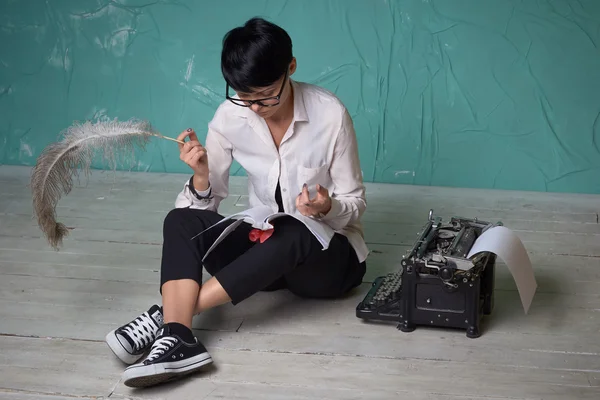 Junge Geschäftsfrau arbeitet mit Dokumenten auf Fußboden, Retro-Schreibmaschine — Stockfoto