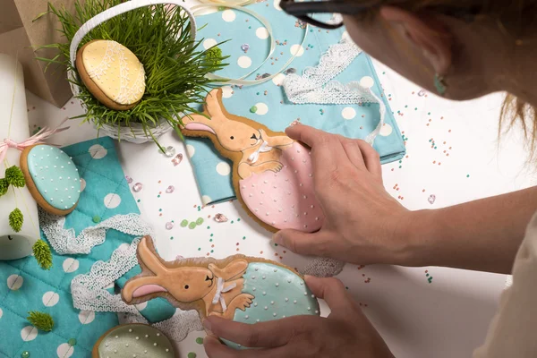 Girl puts easter rabbit honey-cake, holiday preparations, kitchen design — Stock Photo, Image