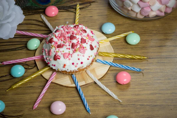 Celebrating sweet cupcake, candles on wooden table, candies birthday party — Stock Photo, Image