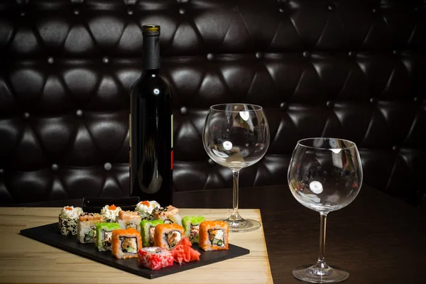 Sushi met rode wijn op een tafel in een restaurant Stockafbeelding