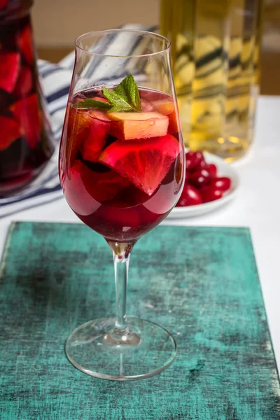 Summer sangria cocktail in wine glass , plate with dogwood berries — Stock Photo, Image