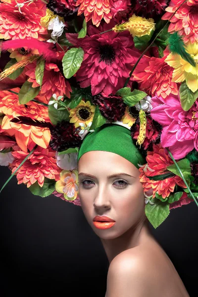 Retrato de mulher jovem bonita com flores penteado e flores de verão laranja. Maquiagem de moda — Fotografia de Stock