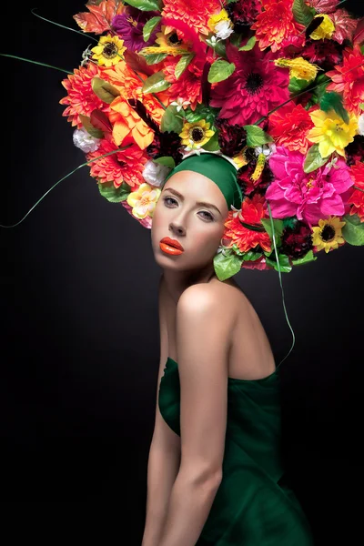 Gyönyörű fiatal nő portré frizura virágok és narancs nyári virágok. Smink divat — Stock Fotó
