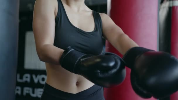 Schöne athletische Frau trainiert Boxen in der Turnhalle und zieht Handschuhe an. — Stockvideo
